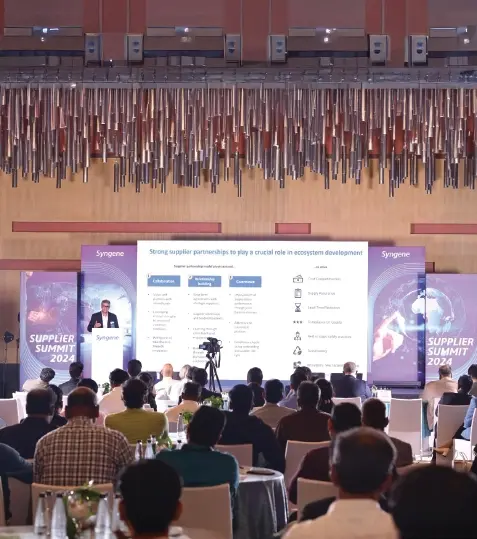 A  group of people in lab coats looking at a machine