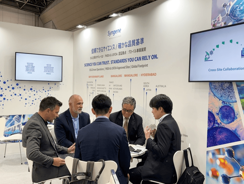 Figure – 3: Syngene team members in discussion with visitors inside the CPHI Japan booth meeting area. Syngene team members in discussion with visitors inside the CPHI Japan booth meeting area